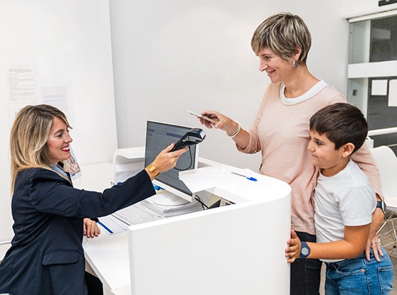 Dental receptionist helping mother and son