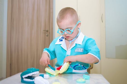 Child playing with a dental model and other dental toys