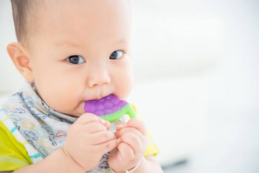 Infant chewing on a teething toy