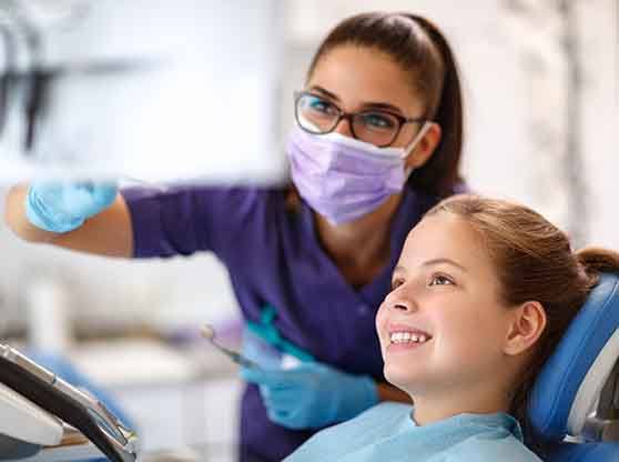 Dentist talking to child about receiving a dental crown