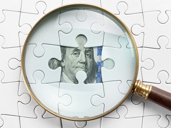Magnifying glass inspecting a dollar bill hidden behind puzzle pieces