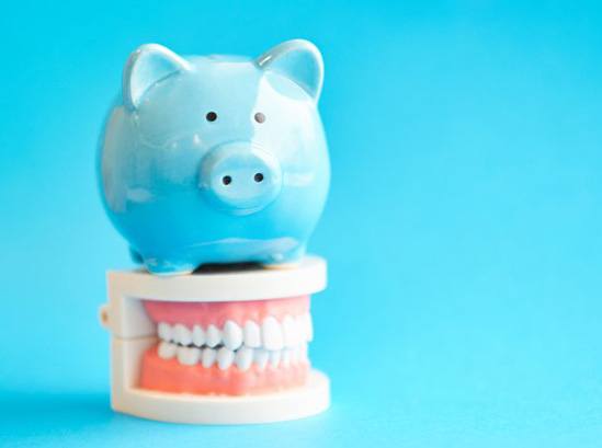 Piggy bank sitting on model teeth